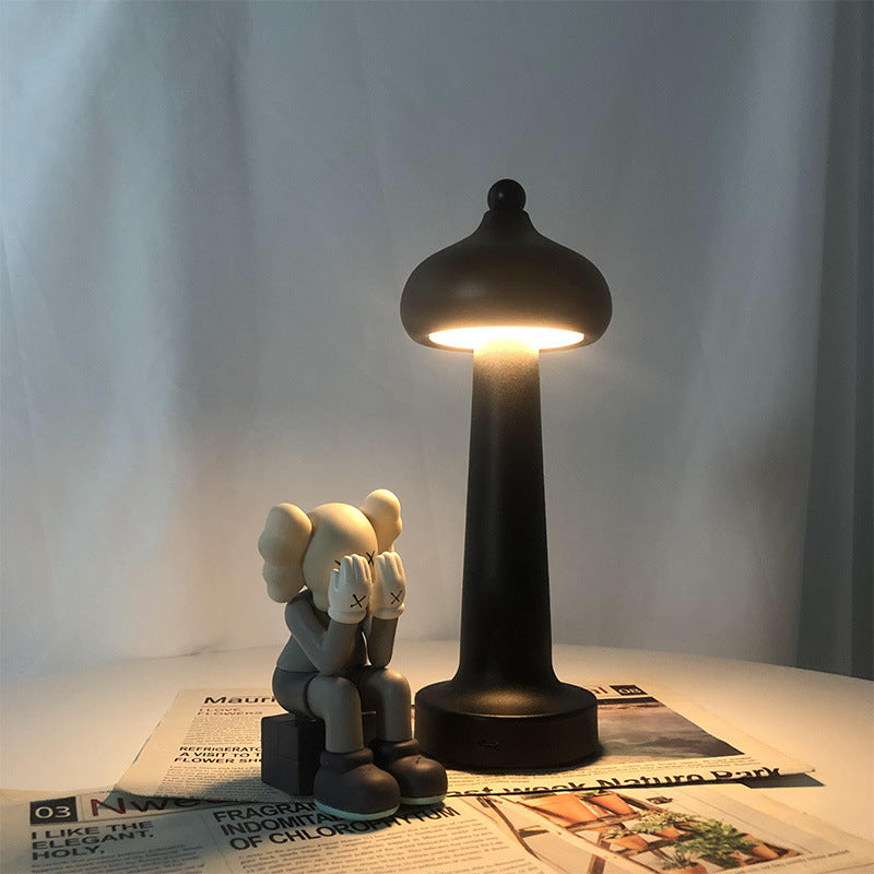 LED night light plugged into wall socket emitting warm amber glow in dim room