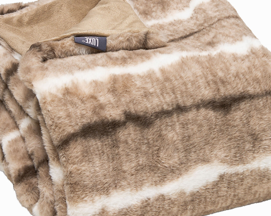 Cream and light brown faux fur throw draped over a sofa or chair