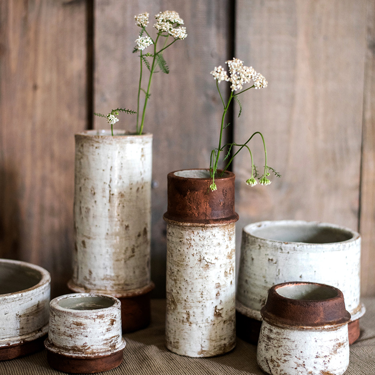 Handmade ceramic vase with rough textured surface finish in neutral tones