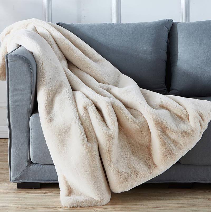 Warm beige chinchilla faux fur throw draped over a sofa or chair