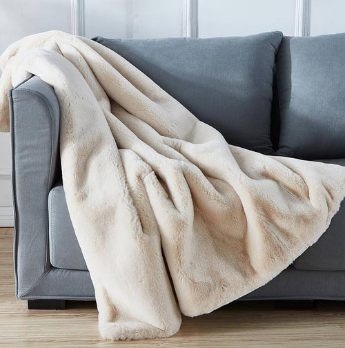 Warm beige chinchilla faux fur throw draped over a sofa or chair