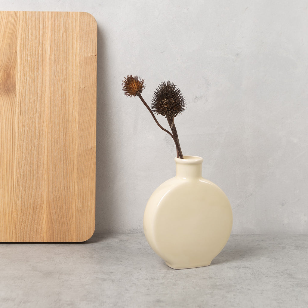 Ivory stoneware flattened bud vase with smooth matte finish and narrow neck