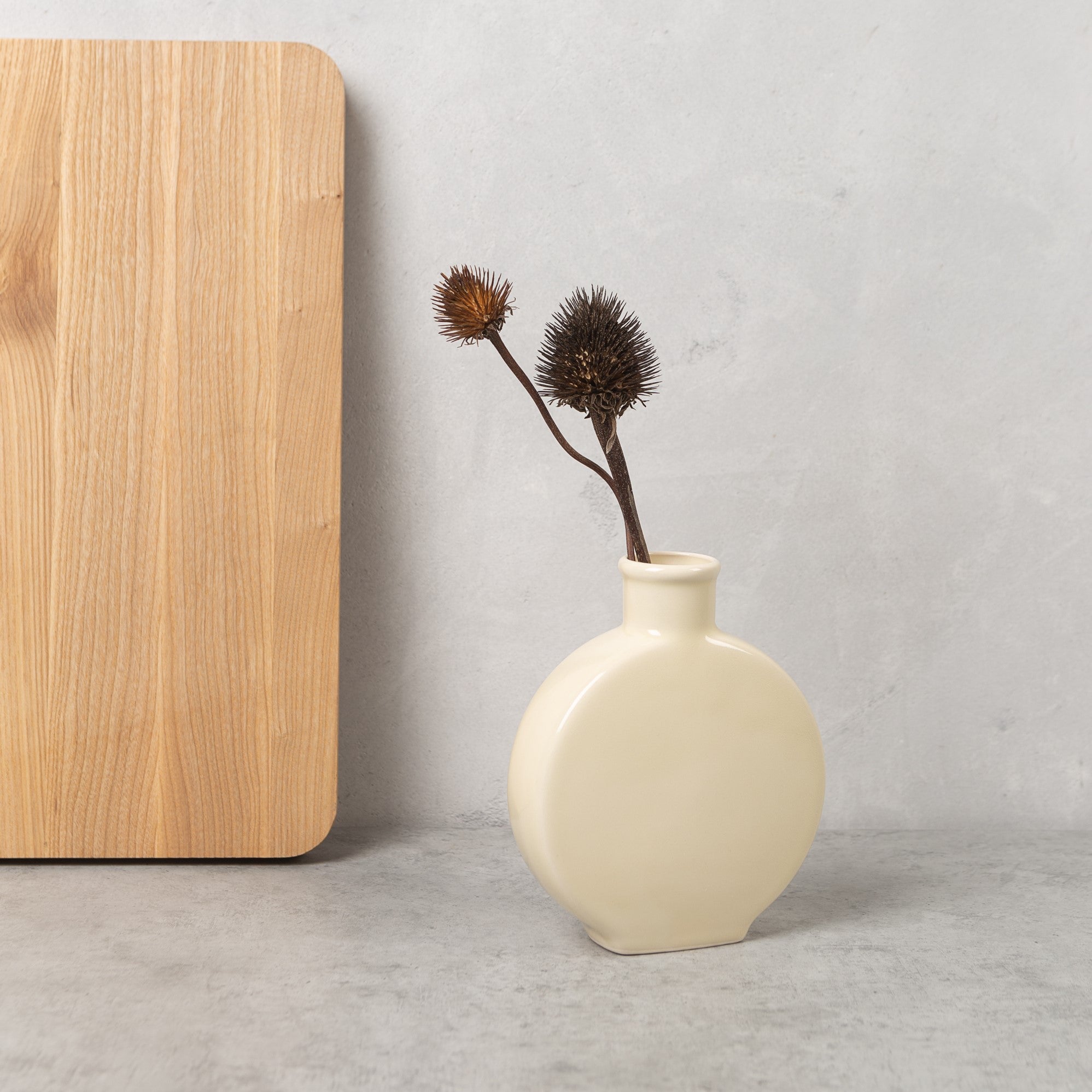Ivory stoneware flattened bud vase with smooth matte finish and narrow neck